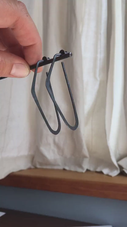Hammered oxidized black silver hoops long d shape.