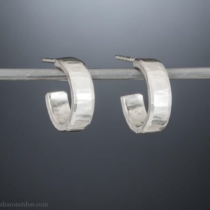 Close up photo of handcrafted 14mm x 4mm hammered solid sterling silver hoop earrings.