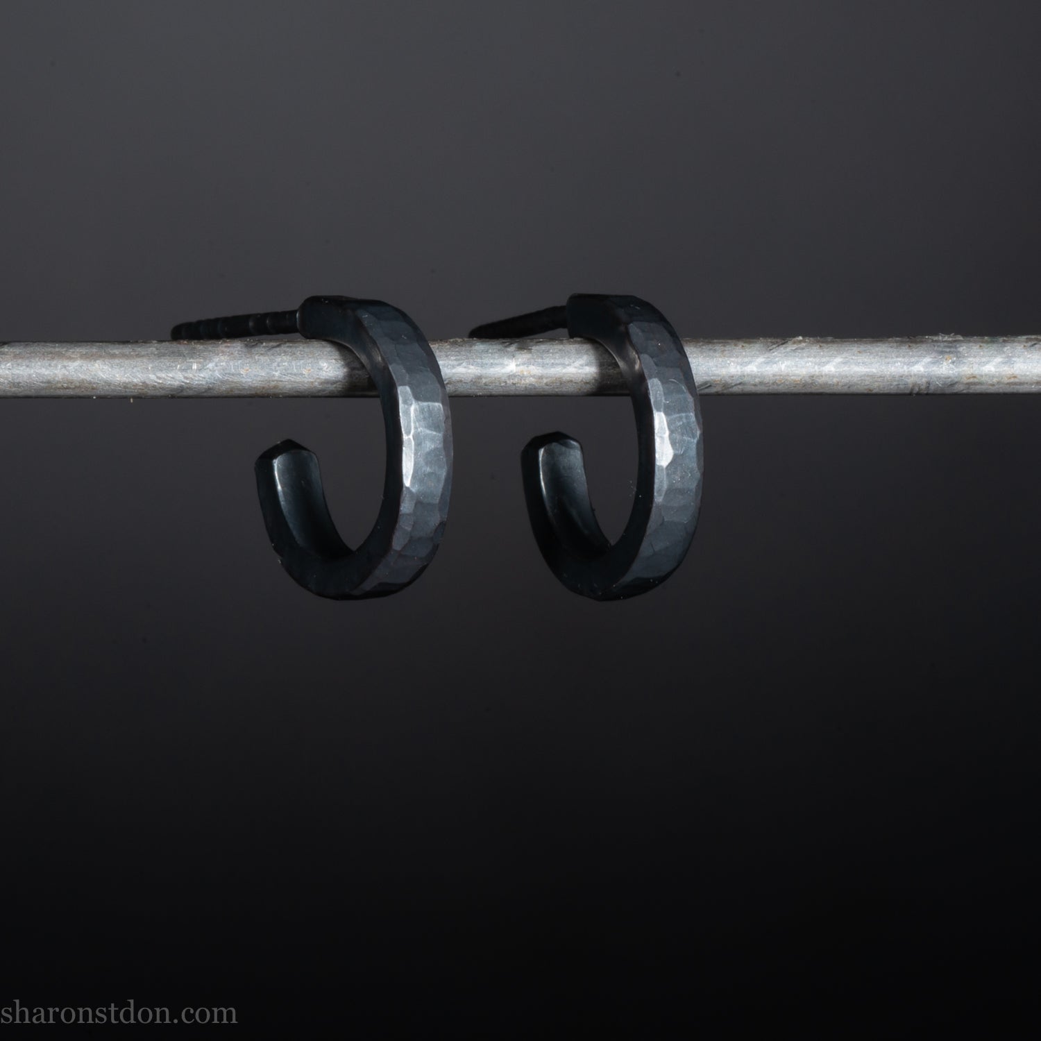 Solid 925 sterling silver hoop earrings for men with an oxidized matte black finish. 12mm exterior diameter, 9mm interior, 2mm wide, and 1.5mm thick. Solid sterling silver posts and backs. Handcrafted, each pair hand hammered by Sharon Saint Don in the Pacific Northwest of the USA.