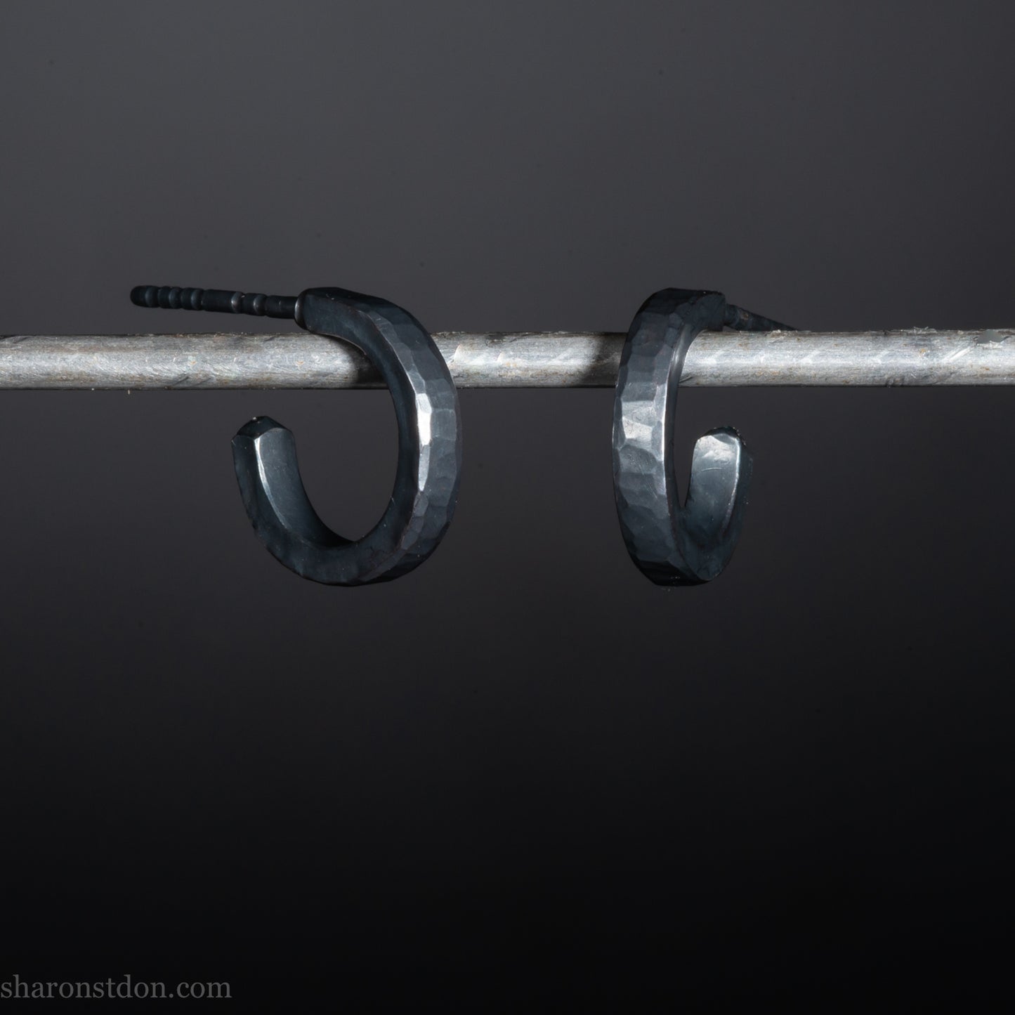 Solid 925 sterling silver hoop earrings for men with an oxidized matte black finish. 12mm exterior diameter, 9mm interior, 2mm wide, and 1.5mm thick. Solid sterling silver posts and backs. Handcrafted, each pair hand hammered by Sharon Saint Don in the Pacific Northwest of the USA.