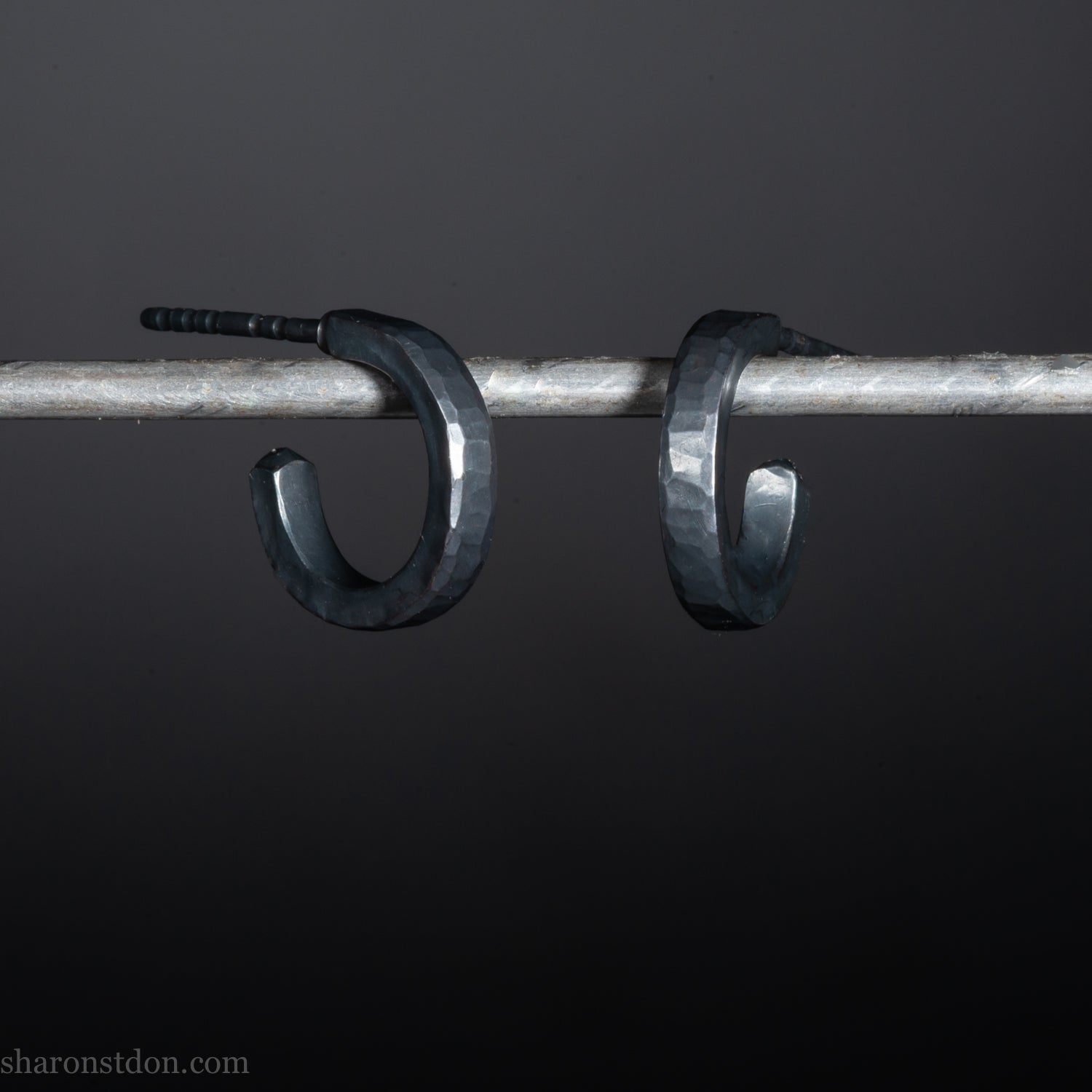 Solid 925 sterling silver hoop earrings for men with an oxidized matte black finish. 12mm exterior diameter, 9mm interior, 2mm wide, and 1.5mm thick. Solid sterling silver posts and backs. Handcrafted, each pair hand hammered by Sharon Saint Don in the Pacific Northwest of the USA.