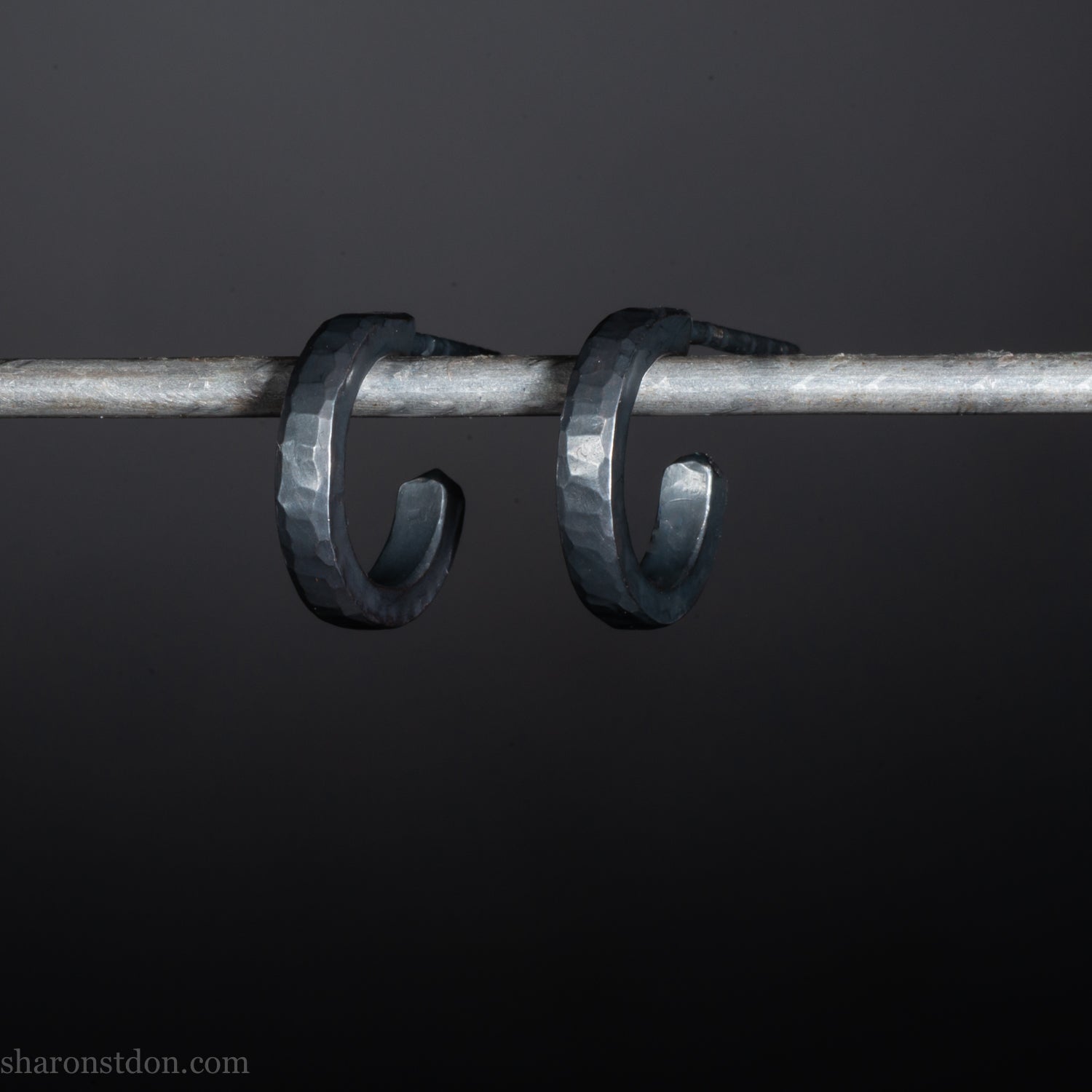 Solid 925 sterling silver hoop earrings for men with an oxidized matte black finish. 12mm exterior diameter, 9mm interior, 2mm wide, and 1.5mm thick. Solid sterling silver posts and backs. Handcrafted, each pair hand hammered by Sharon Saint Don in the Pacific Northwest of the USA.