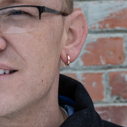 14k yellow gold hammered hoop earring, 14mm diameter, matte brushed finish, worn on ear.