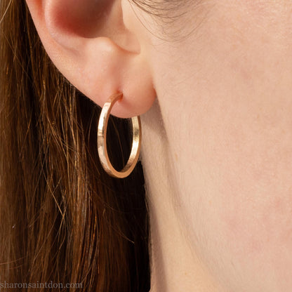 20mm solid yellow gold hoop earrings with hammered matte finish and solid gold posts, handmade by Sharon SaintDon