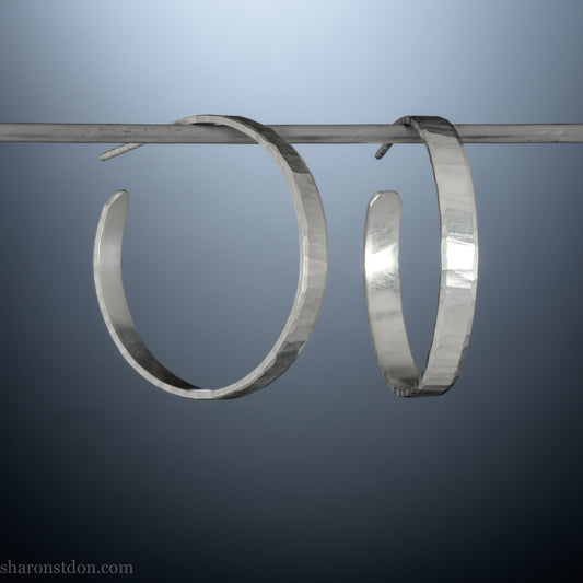 Hand hammered solid sterling silver hoop earrings with faceted, wavy texture and matte satin finish, 30 mm x 4 mm.