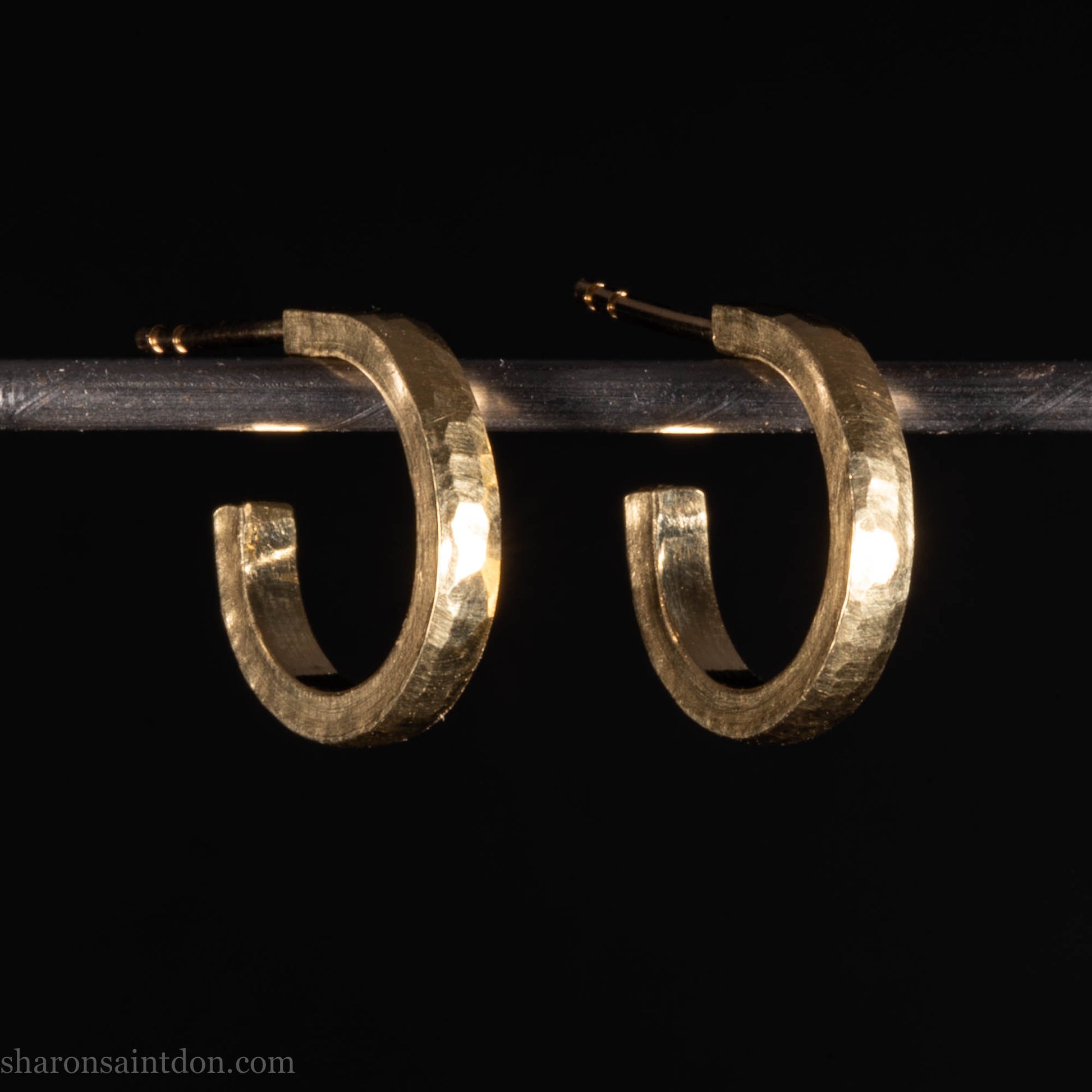 Hammered solid 18k yellow gold hoop earrings. 18mm diameter, 2mm wide, with a matte, brushed finish. Solid 18k gold posts and locking backs. Handmade by Sharon SaintDon in North America.