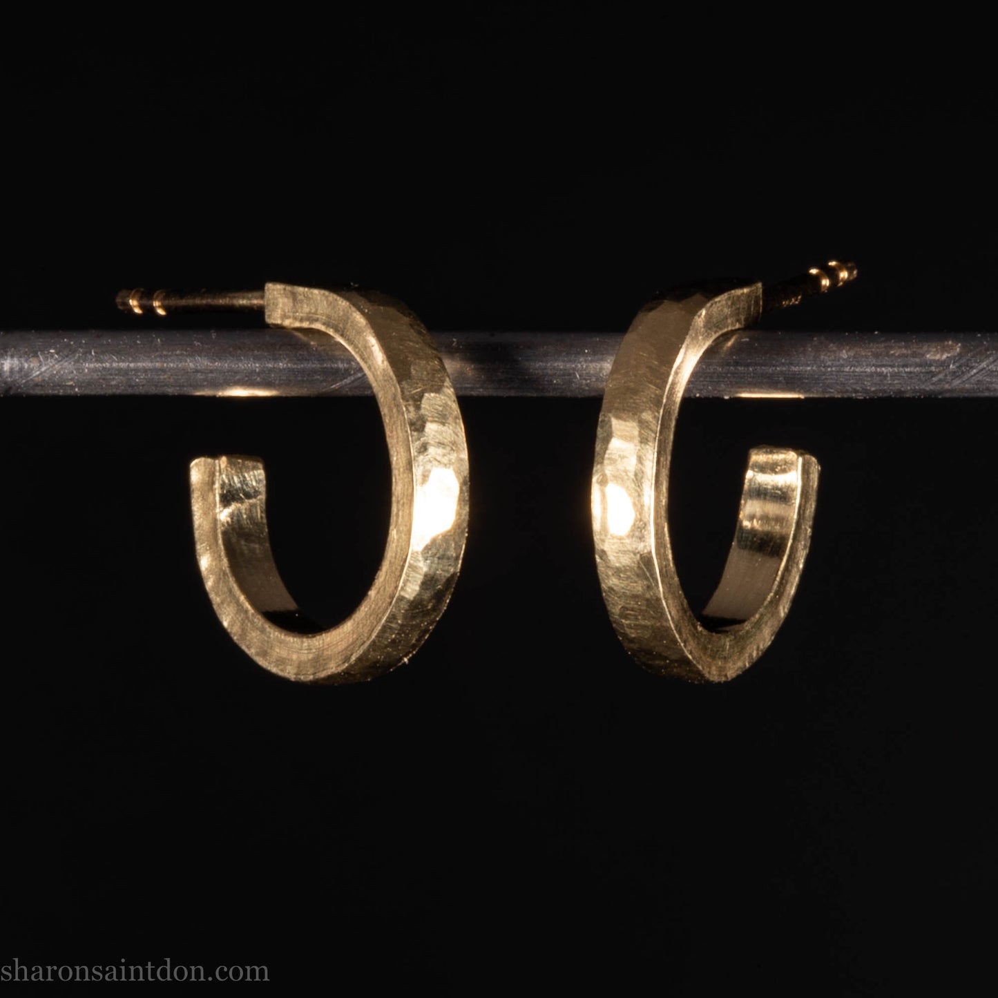 Hammered solid 18k yellow gold hoop earrings. 18mm diameter, 2mm wide, with a matte, brushed finish. Solid 18k gold posts and locking backs. Handmade by Sharon SaintDon in North America.