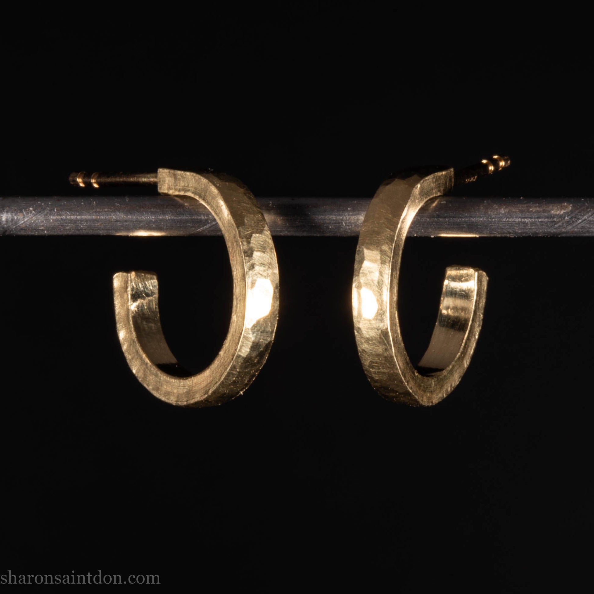Hammered solid 18k yellow gold hoop earrings. 18mm diameter, 2mm wide, with a matte, brushed finish. Solid 18k gold posts and locking backs. Handmade by Sharon SaintDon in North America.