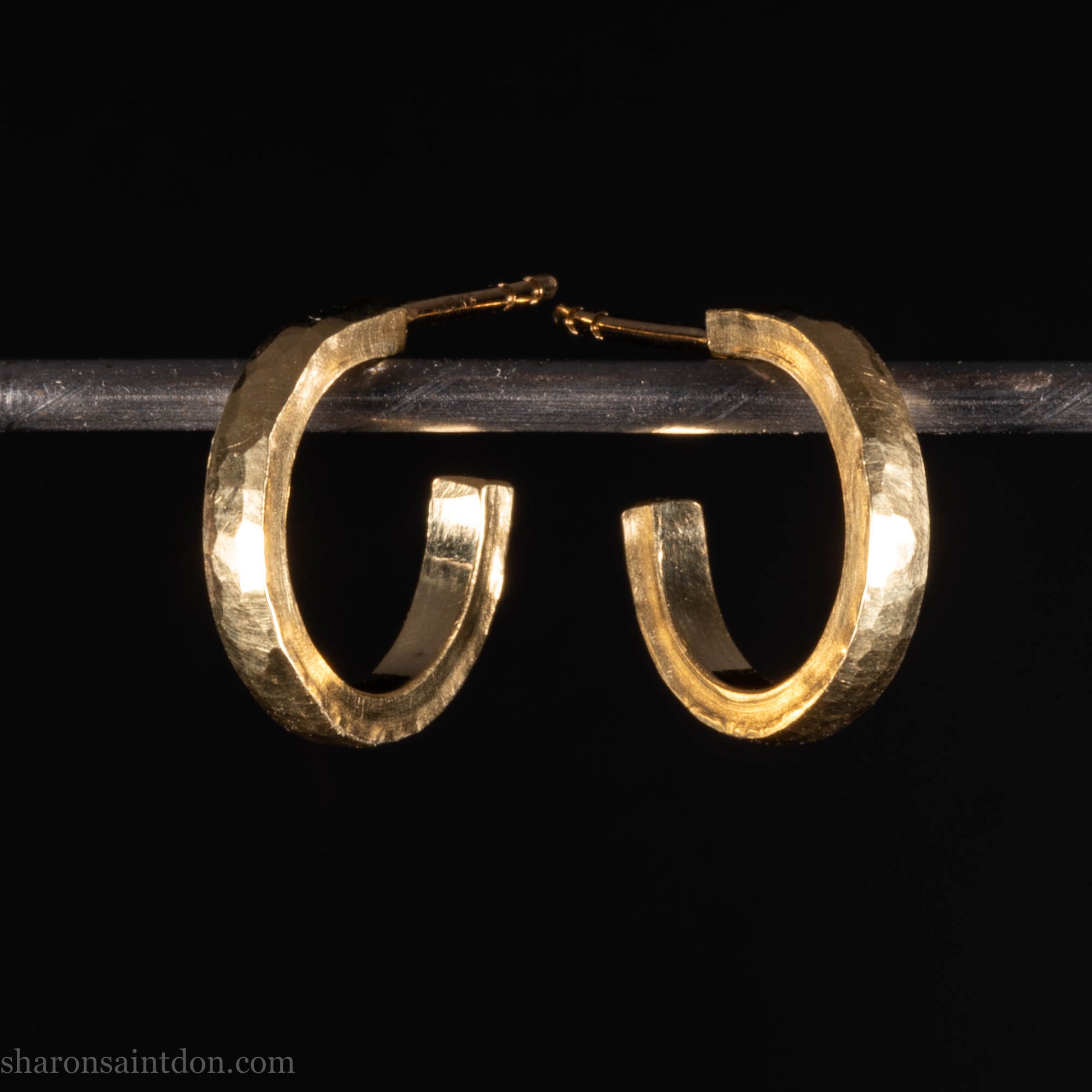 Hammered solid 18k yellow gold hoop earrings. 18mm diameter, 2mm wide, with a matte, brushed finish. Solid 18k gold posts and locking backs. Handmade by Sharon SaintDon in North America.