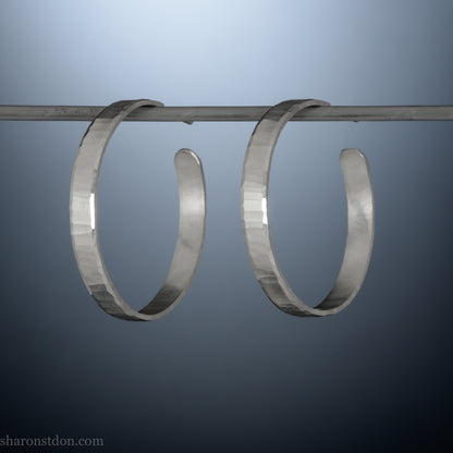 Hand hammered solid sterling silver hoop earrings with faceted, wavy texture and matte satin finish, 30 mm x 4 mm.