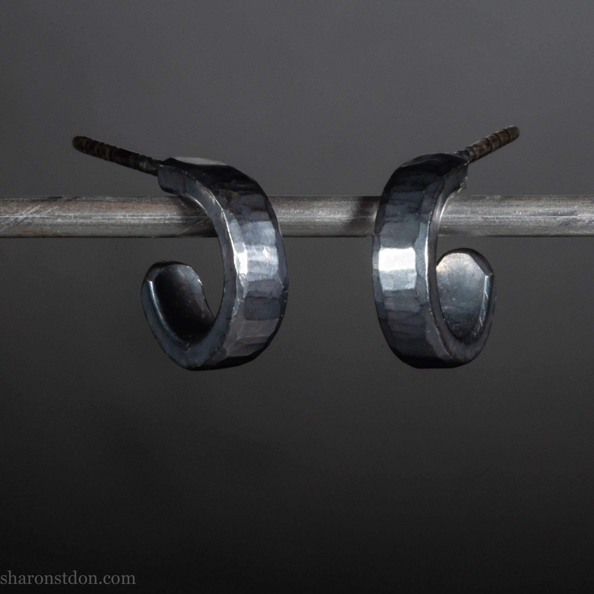 Hammered solid 925 silver hoop earrings with an oxidized black finish. 12mm exterior diameter, 9mm interior, 3mm wide. and 1.5mm thick. Solid sterling silver posts and backs. Handcrafted by Sharon Saint Don in the USA.
