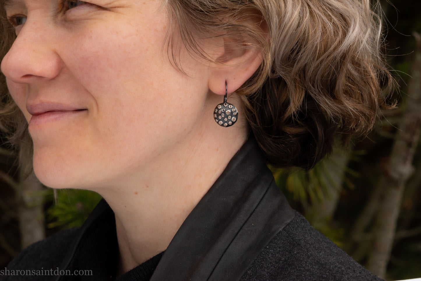 15mm solid 925 sterling silver round disc earrings, hand-punched pattern, dark antique patina, french hooks, worn on an ear.