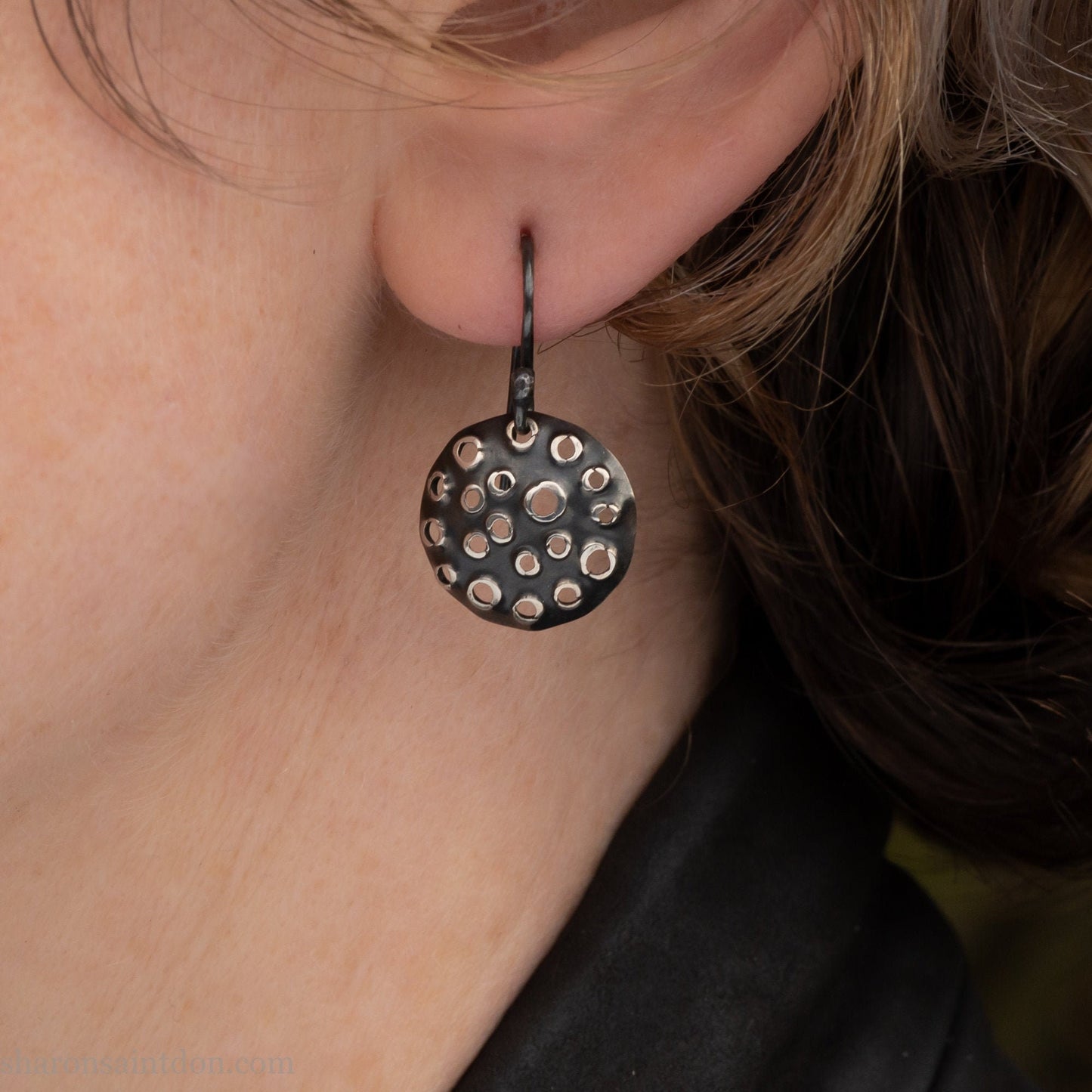 15mm solid 925 sterling silver round disc earrings, hand-punched pattern, dark antique patina, french hooks, worn on an ear.
