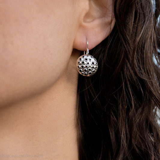 15mm solid 925 sterling silver round disc earrings, hand-punched pattern, matte satin finish, french hooks, worn on an ear.