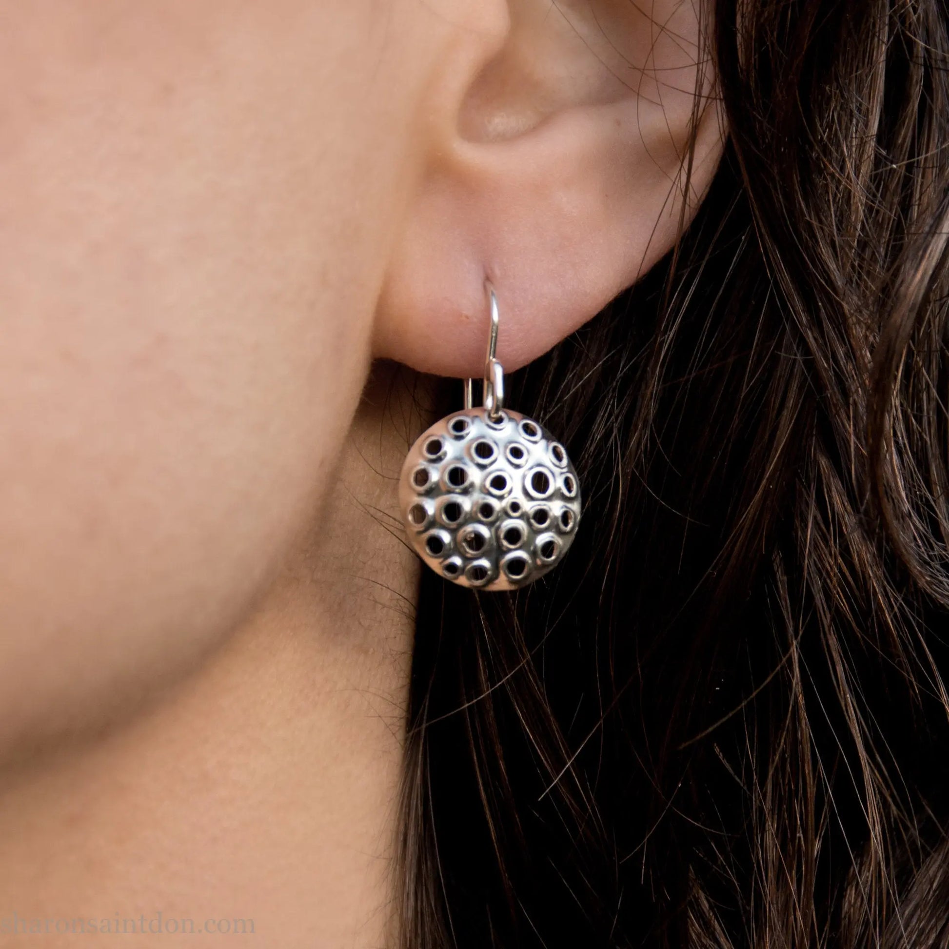 15mm solid 925 sterling silver round disc earrings, hand-punched pattern, matte satin finish, french hooks, worn on an ear.