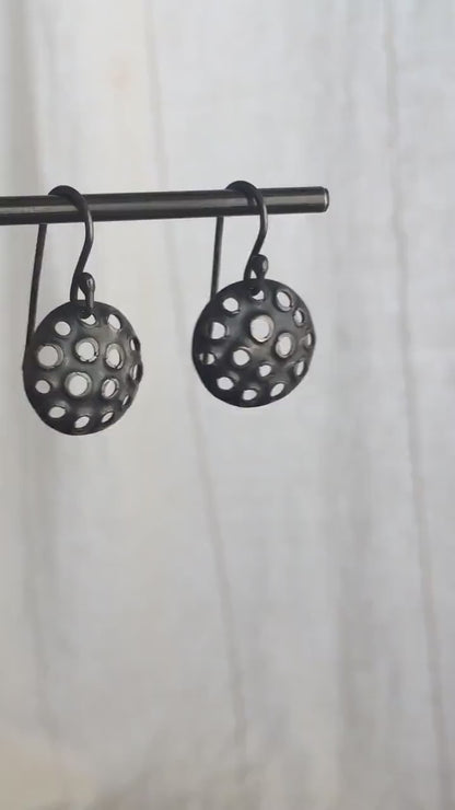15mm round 925 sterling silver disc earrings with mesh perforated holes. Handmade solid oxidized black silver dangle earrings by Sharon SaintDon in North America with hand made black silver french ear hooks.