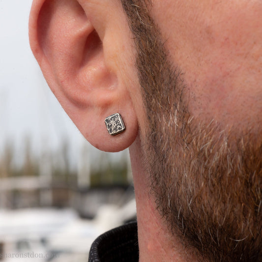 7mm square solid 925 sterling silver stud earrings, dark antique finish, on ear of man with beard.