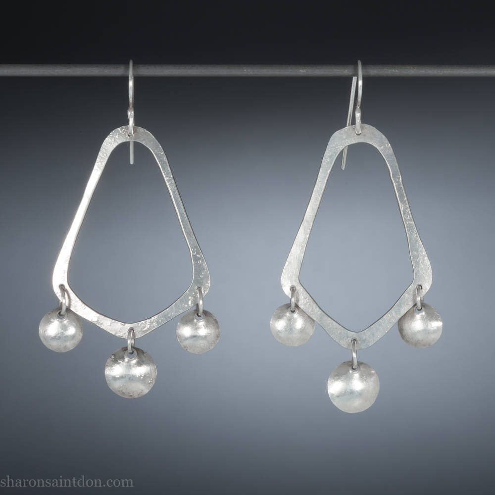 925 sterling silver handcrafted earrings. A hammered, angular, teardrop loop with three dots hanging from the angled teardrop points. Size: 60mm high to top of hook x 35mm at widest point, dots approximately 1cm. Comfortable, lightweight, with handmade ear wire hooks.