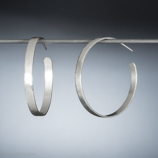 Solid large 925 sterling silver hoop earrings. Handmade by Sharon SaintDon in North America. 50mm diameter, 2mm wide, 1.5mm thick, Brushed, matte finish and silver posts and backs.