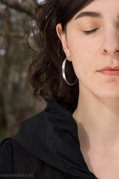Solid 925 sterling silver hoop earrings. Handmade by Sharon SaintDon in North America. 40mm diameter, 2mm wide, 1.5mm thick, Brushed, matte finish and silver posts and backs.