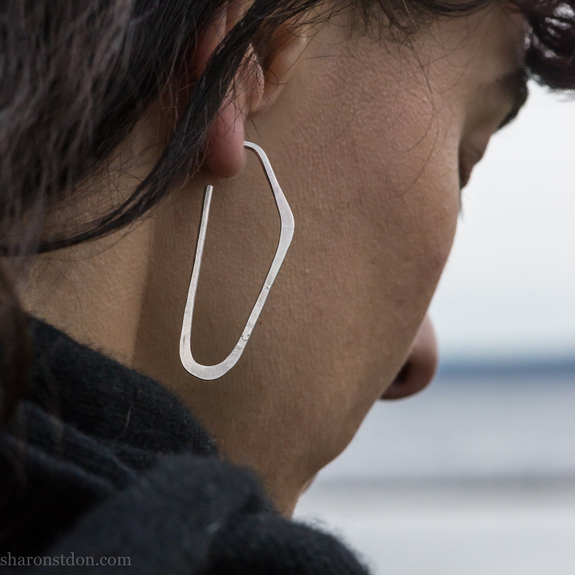 Solid 925 sterling silver hoop earrings, hammered, angular long high D shape. Matte finish, worn on ear.