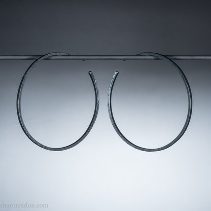 Solid 925 sterling silver hoop earrings. Oxidized black, 50mm diameter, 2mm wide, 1.5mm thick. Lightweight hammered large hoop earrings handmade by Sharon SaintDon in North America.