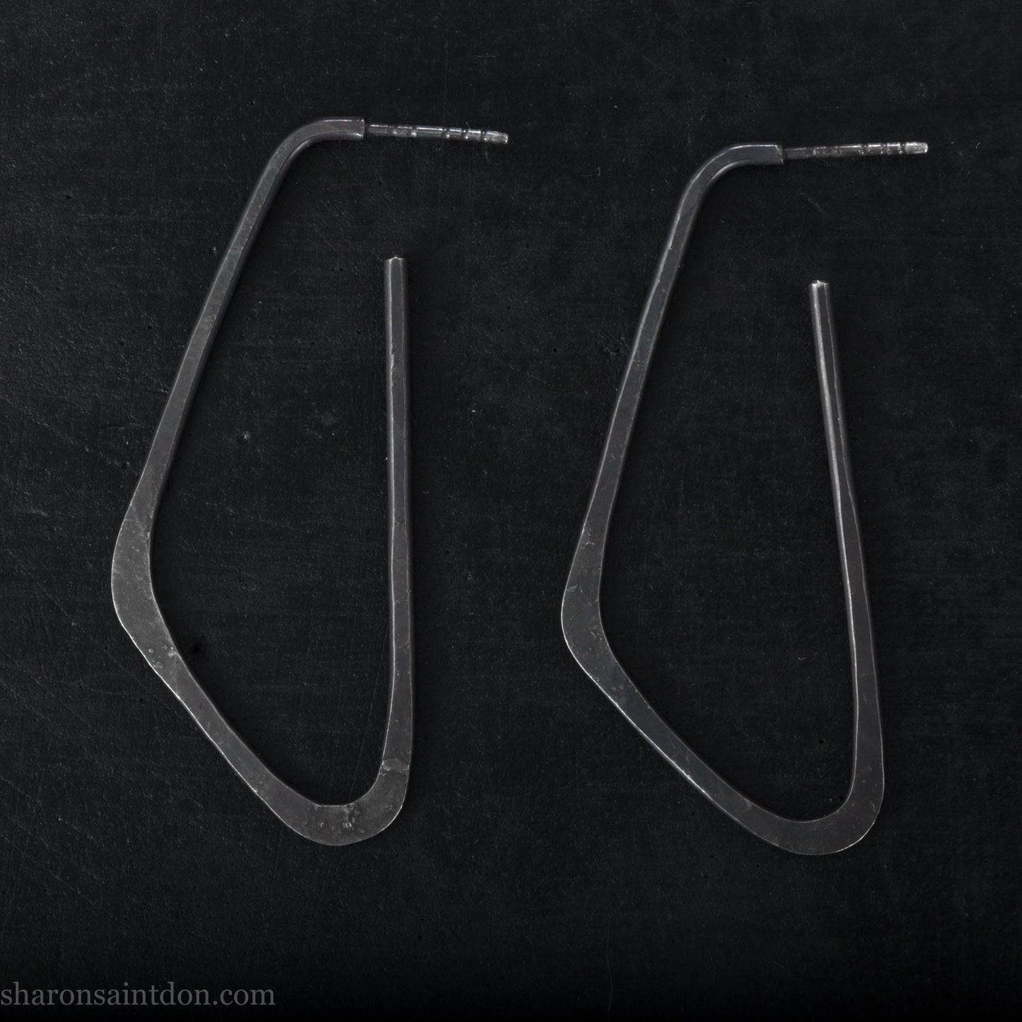 925 sterling silver hoop earrings. Long, angular, low D shape, oxidized black with hammered texture. SIZE: 5cm high x 32mm wide.