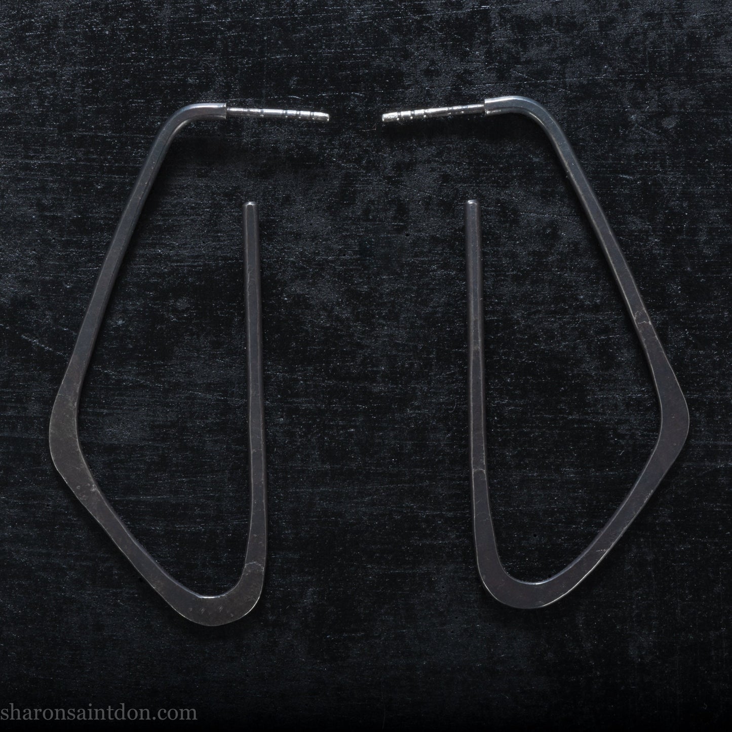 925 sterling silver hoop earrings. Long, angular, low D shape, oxidized black with hammered texture. SIZE: 5cm high x 32mm wide.