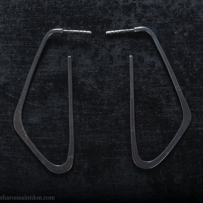 925 sterling silver hoop earrings. Long, angular, low D shape, oxidized black with hammered texture. SIZE: 5cm high x 32mm wide.