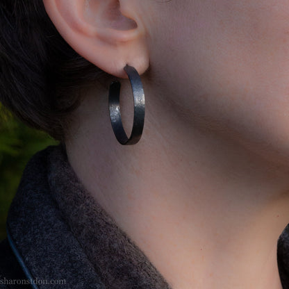 925 sterling silver hoop earrings. 30mm diameter round, 5mm wide, Handmade oxidized black by Sharon SaintDon. Solid Hammered silver with silver posts and backs.