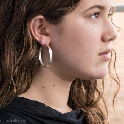 Solid 925 sterling silver hoop earrings. 40mm diameter, 5mm wide, .75 thick. Hammered texture, silver posts and backs. Handmade in USA by Sharon Saint Don.
