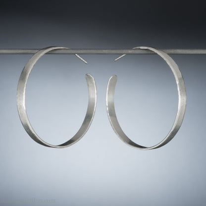 925 sterling silver hoop earrings handmade by Sharon SaintDon in the USA. 30mm diameter, 2mm wide, solid hammered silver. Oxidized black with sterling silver posts and backs.