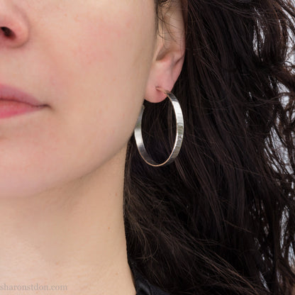 Solid 925 sterling silver hoop earrings handmade by Sharon SaintDon in the USA. 40mm diameter, 5mm wide, Matte shiny finish, hammered wavy texture, sterling silver posts and backs.