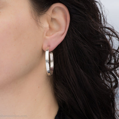 Solid 925 sterling silver hoop earrings handmade by Sharon SaintDon in the USA. 40mm diameter, 5mm wide, Matte shiny finish, hammered wavy texture, sterling silver posts and backs.
