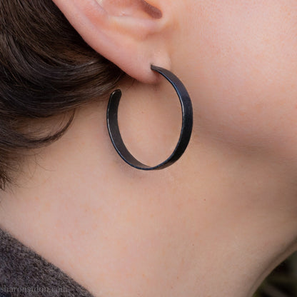 925 sterling silver hoop earrings. 30mm diameter round, 5mm wide, Handmade oxidized black by Sharon SaintDon. Solid Hammered silver with silver posts and backs.