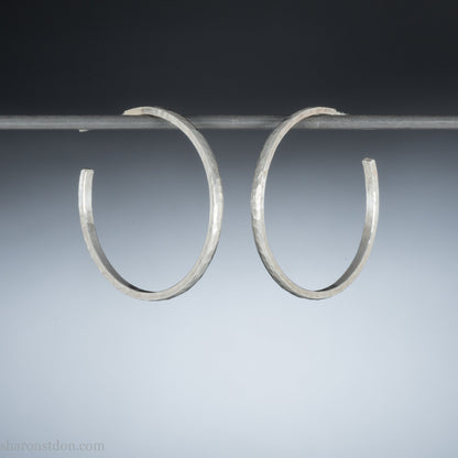 Handmade solid 925 sterling silver hoop earrings. 30mm diameter, 2mm wide, 1.5 thick. Silver posts and backs. Hammered by Sharon SaintDon in North America.