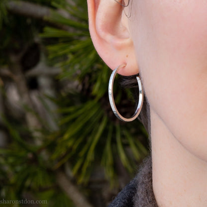 Handmade solid 925 sterling silver hoop earrings. 30mm diameter, 2mm wide, 1.5 thick. Silver posts and backs. Hammered by Sharon SaintDon in North America.