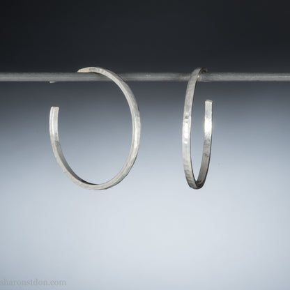 Handmade solid 925 sterling silver hoop earrings. 30mm diameter, 2mm wide, 1.5 thick. Silver posts and backs. Hammered by Sharon SaintDon in North America.