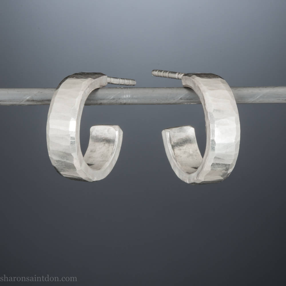 14mm x 4mm small sterling silver hoop earrings, Handmade in North America by Sharon SaintDon. Shiny, hammered texture, solid silver with silver posts and backs for men or women.