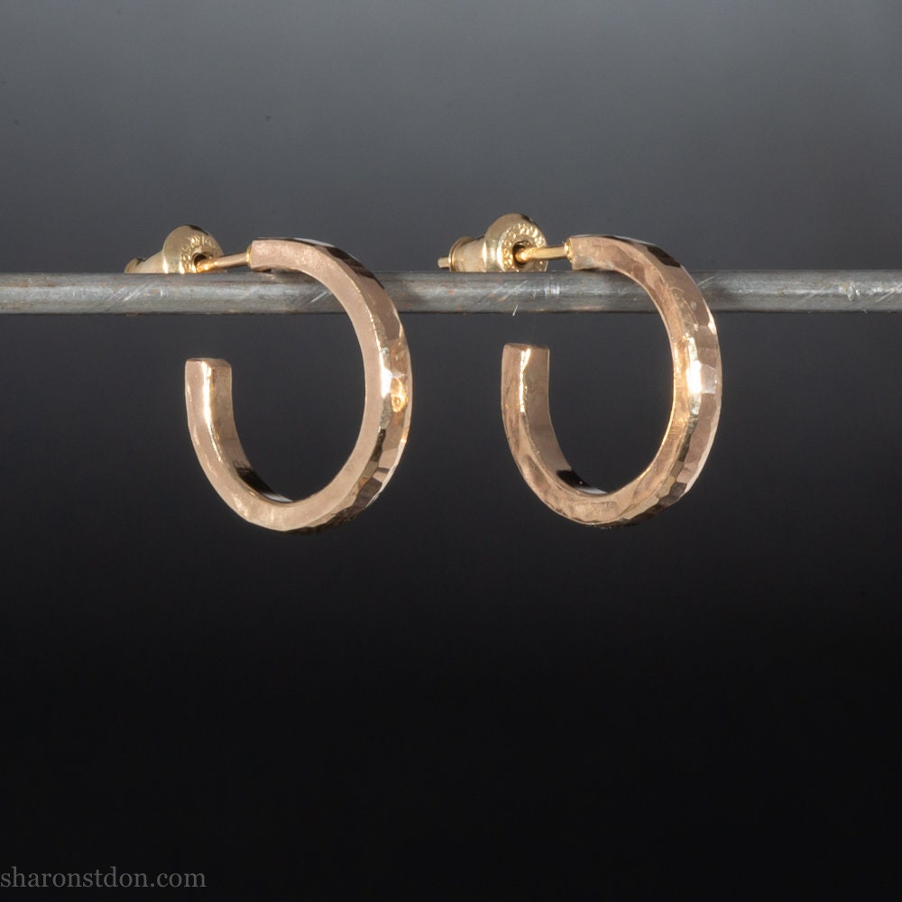16mm diameter sold hoop earrings set handmade in North America by Sharon SaintDon. Hammered solid yellow gold, 2mm wide, 1.5mm thick, with 14k gold posts and locking backs.