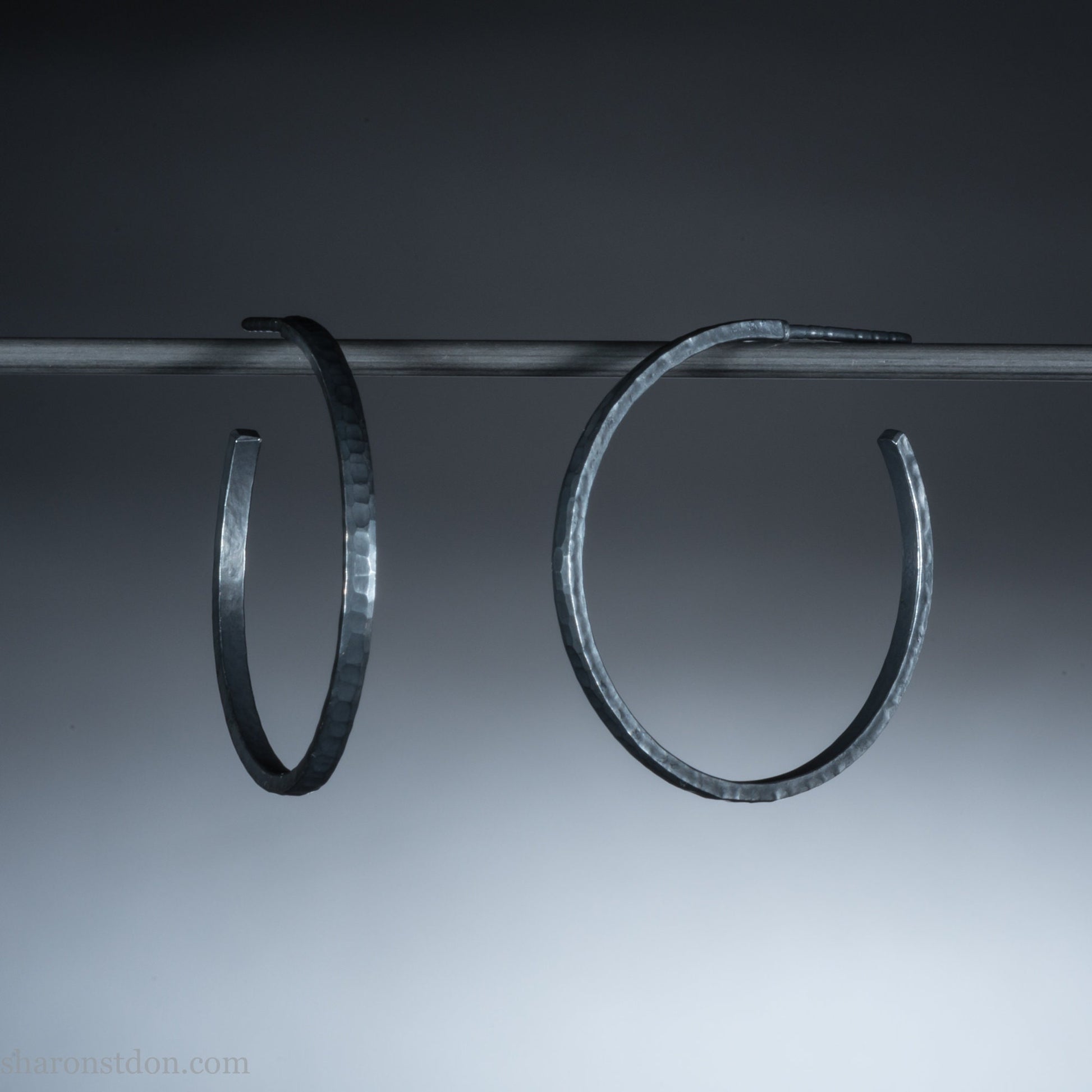 925 sterling silver hoop earrings handmade  for women by Sharon SaintDon in the USA. 30mm diameter, 2mm wide, solid hammered silver, oxidized black.