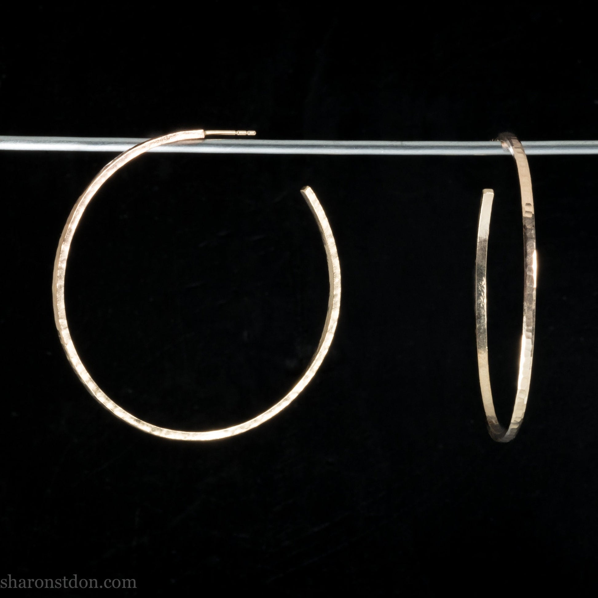 Gold hoop earrings handmade from solid yellow gold in the USA for women. Size large, 50mm diameter, hammered texture.
