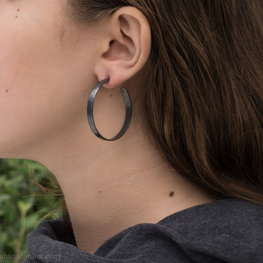 Solid 925 sterling silver hoop earrings for women. Hand hammered, oxidized black, 40mm diameter, 5mm wide comfortable, lightweight. Handmade by Sharon SaintDon in Pacific Northwest, North America.