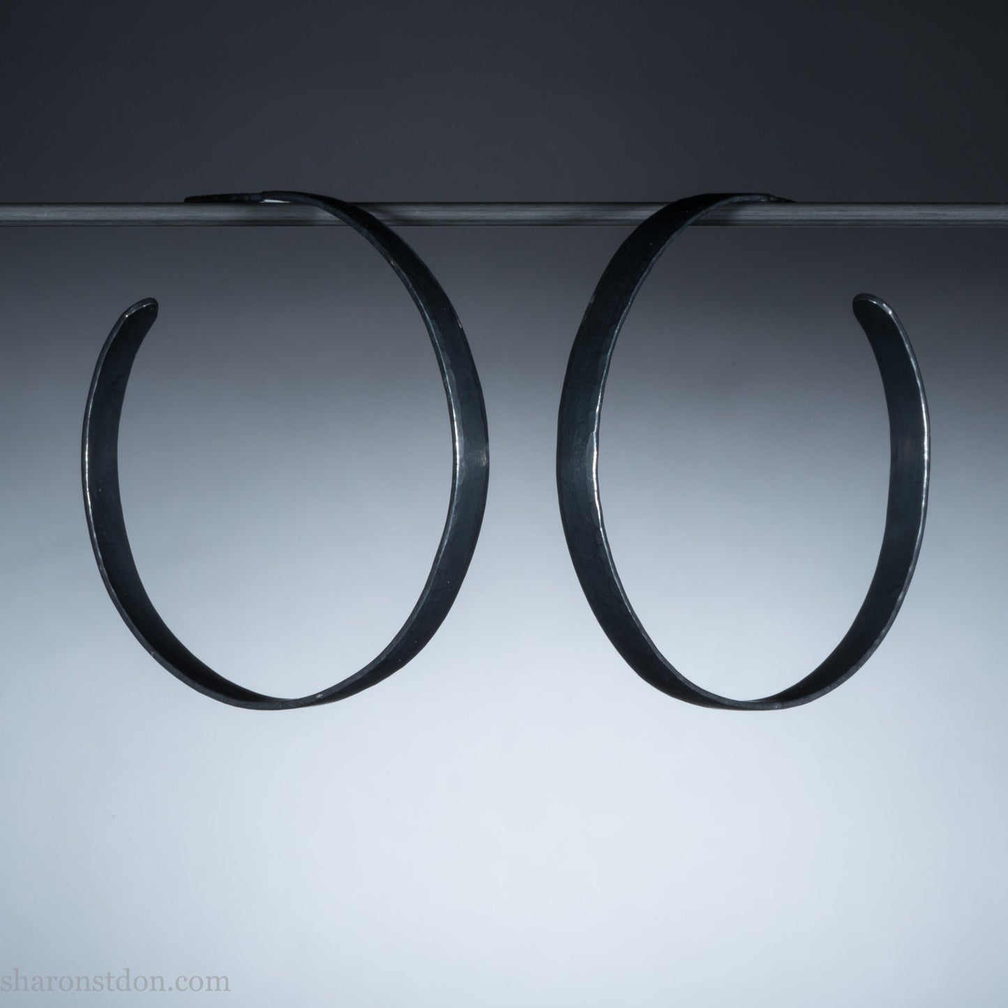 Handmade 925 sterling silver hoop earrings for women. Oxidized black, lightweight large hoop earrings handmade and hammered by Sharon SaintDon in the Pacific Northwest of the USA. 50mm diameter, 5mm wide.