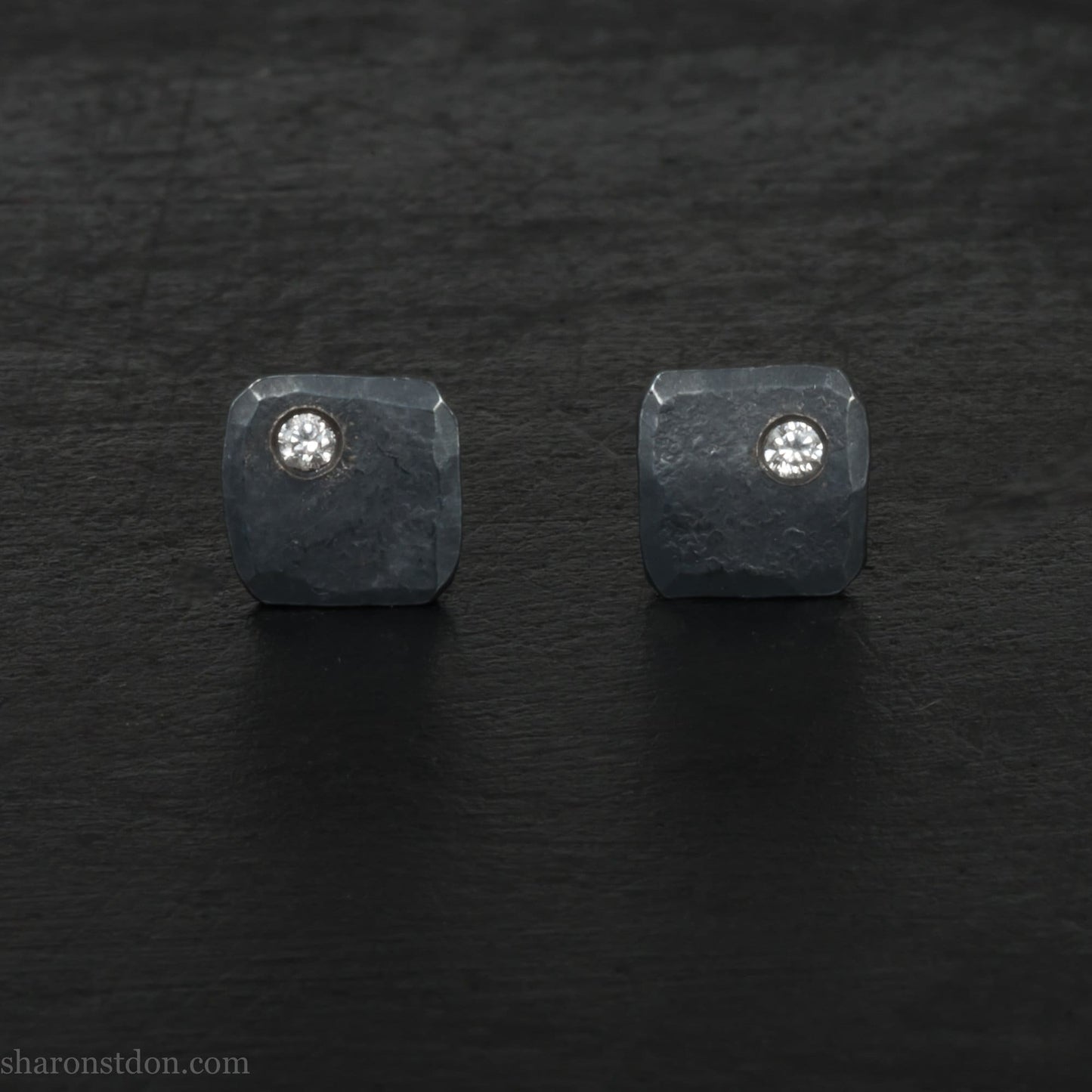 7mm x 7mm square, oxidized black, 925 sterling silver stud earrings with Canadian diamond in the corner. Handmade by Sharon SaintDon in North America with Canadamark diamonds for men or women, non binary.