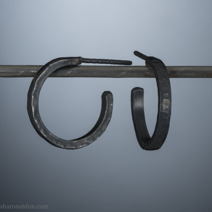 18mm x 2mm oxidized black 925 sterling silver hoop earrings for men. Hammered texture, matte, flat black handmade by Sharon SaintDon in North America.