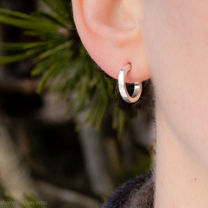 14mm x 2mm small sterling silver hoop earrings, Handmade in North America by Sharon SaintDon. Hammered texture, solid silver with silver posts and backs for men or women, unisex.