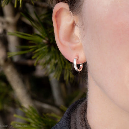 14mm x 2mm small sterling silver hoop earrings, Handmade in North America by Sharon SaintDon. Hammered texture, solid silver with silver posts and backs for men or women, unisex.