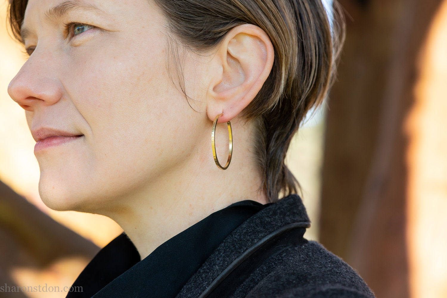 Solid 18k yellow gold hoop earrings set, handmade in North America by Sharon SaintDon.30mm diameter round, 2mm wide, 1.5mm thick, with hammered texture and matte finish.