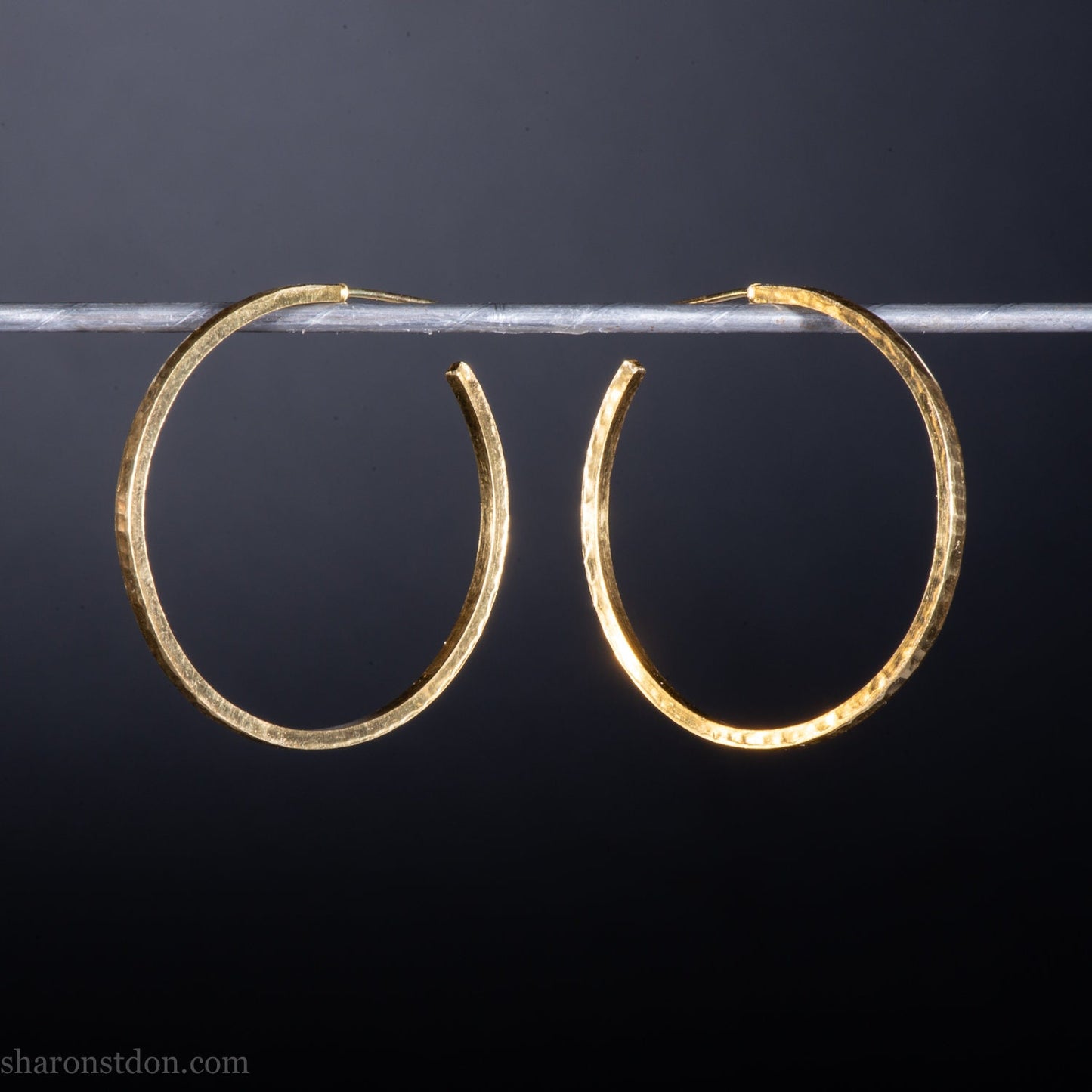 30mm diameter by 1.5mm thick handmade solid 14k yellow gold hoop earrings. Handmade by Sharon SaintDon in North America. Hammered from solid gold with a matte finish.